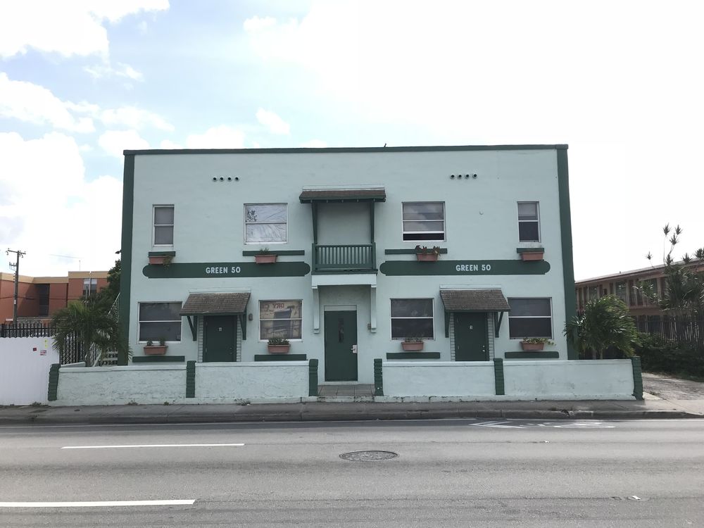A green two-storey eleven-unit apartment building in Little Haiti bought by Johnson Buys