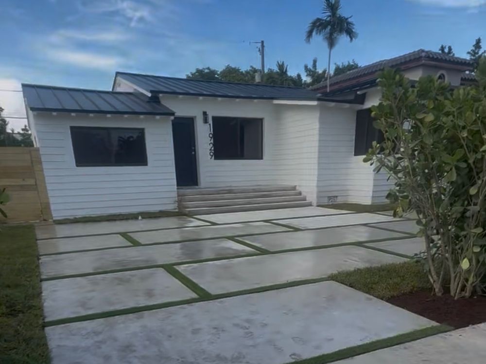 The same Shenandoah house after a full gut renovation, white with a black standing-seam roof and a new poured driveway