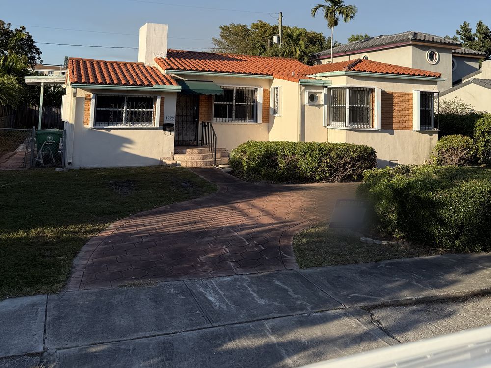 A Shenandoah house before renovation, cream stucco with a barrel tile roof and green awnings